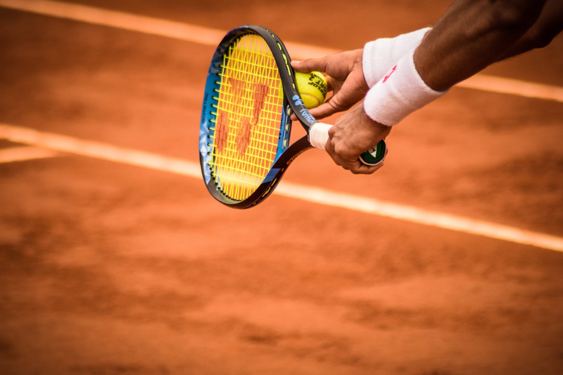 close up photo of person holding tennis racket and ball